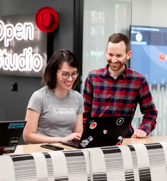 two associates smiling at a laptop screen